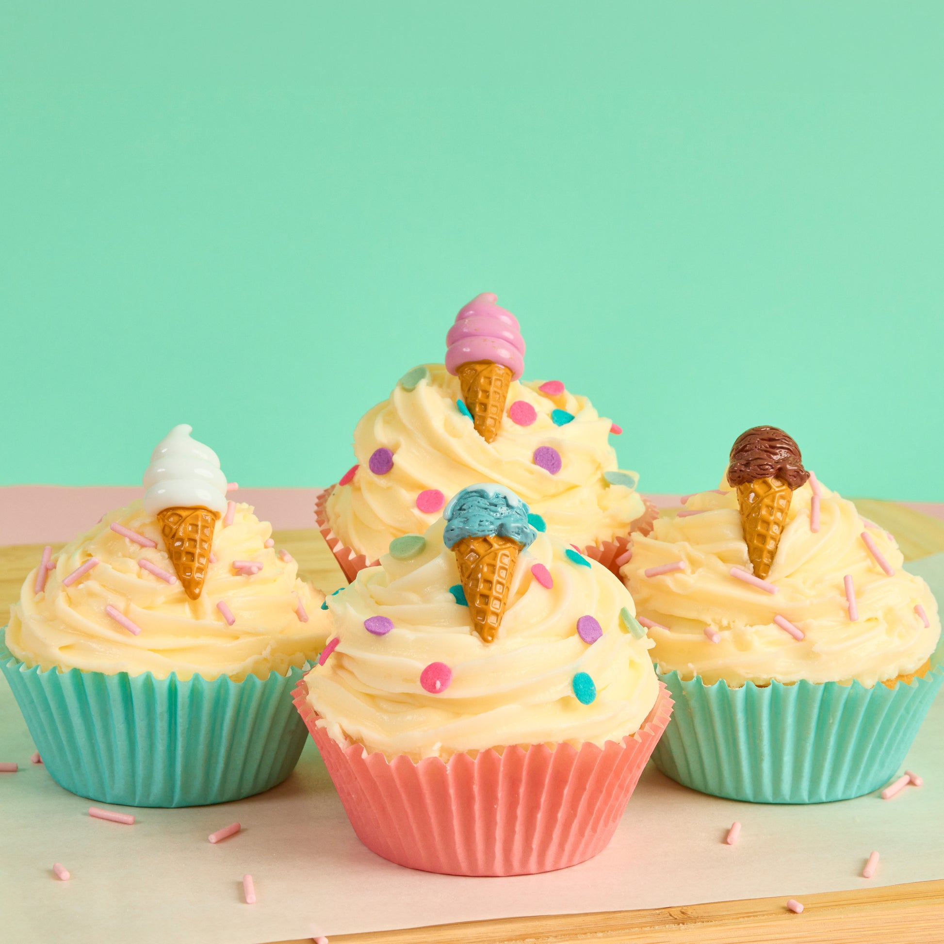 Ice cream pin brooches displayed in decorated cupcakes with buttercream frosting and sprinkles in a colourful themed lifestyle scene