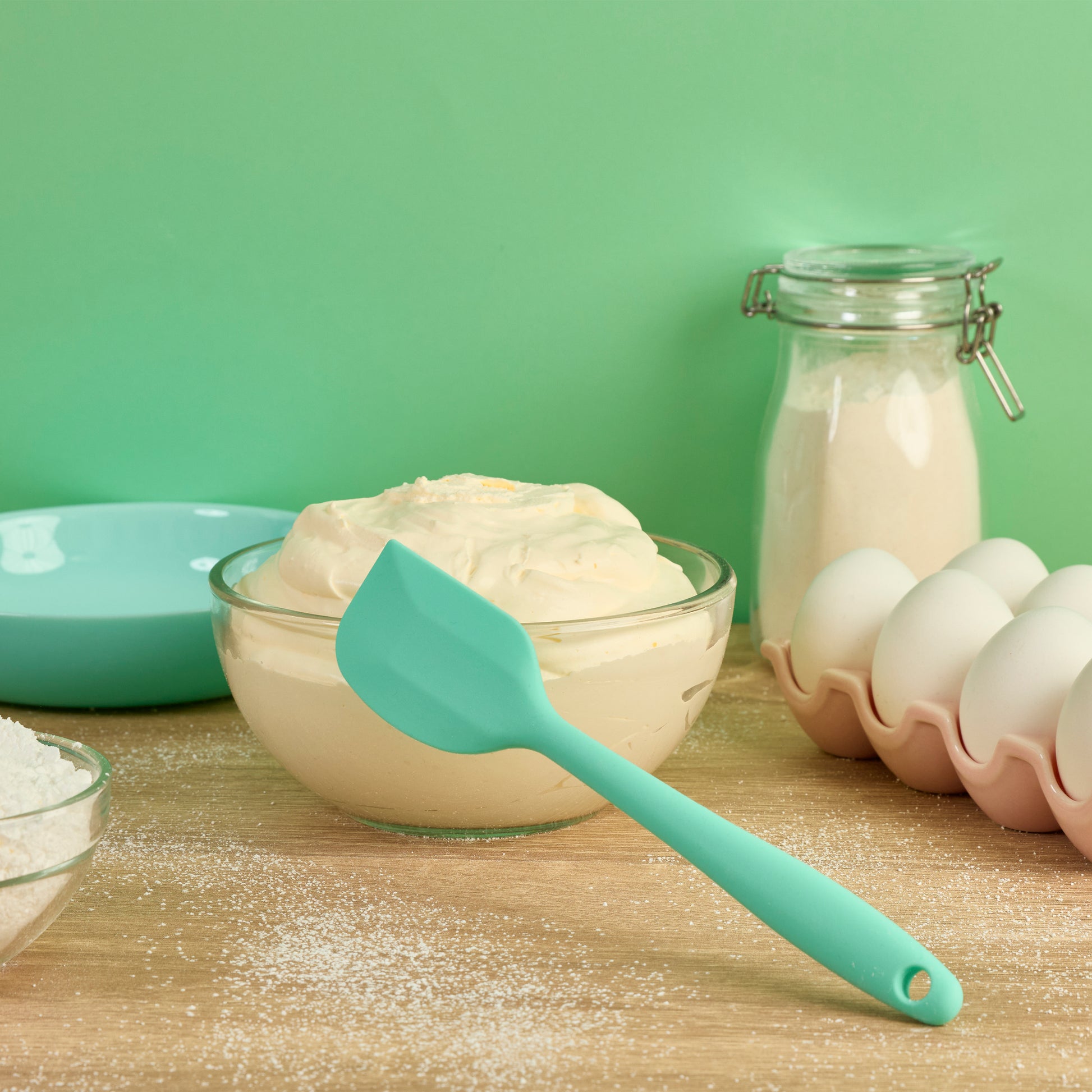 Mint green silicone spoon spatula for mixing cake batter folding ingredients scraping bowls spreading frosting and preparing homemade dessert recipes